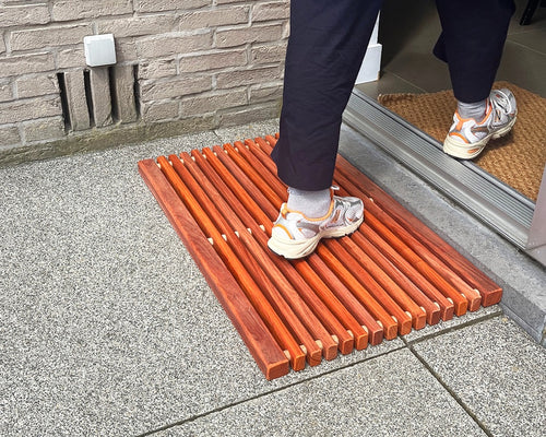 Paillasson en bois de padouk devant la porte d’entrée