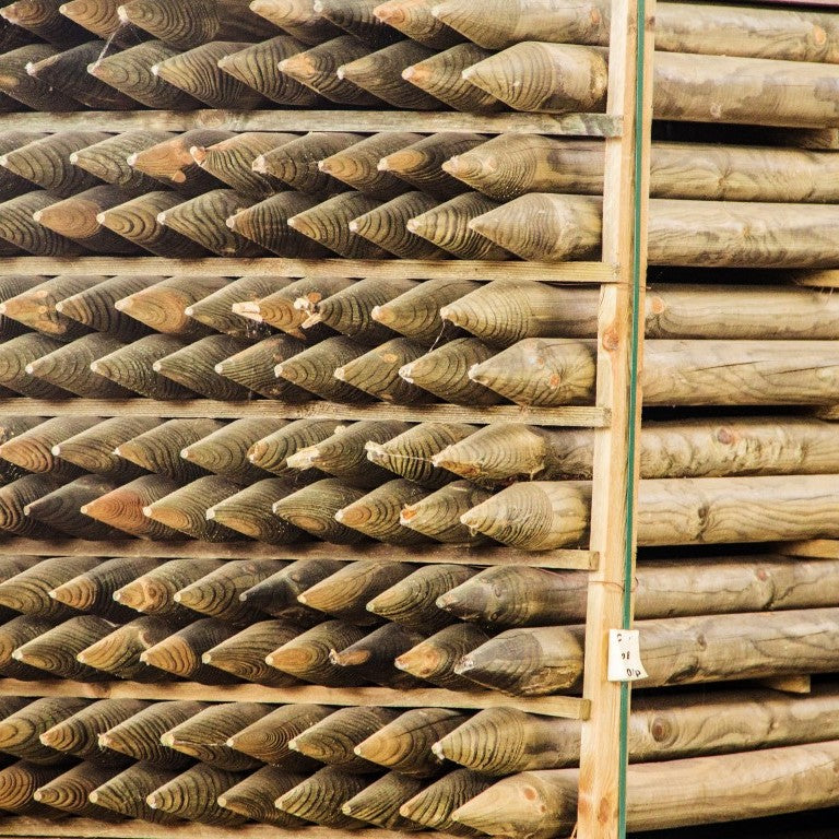 Pile de poteaux ronds en pin appointés